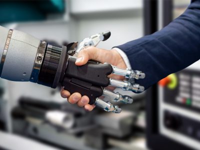 Hand of a businessman shaking hands with a Android robot.