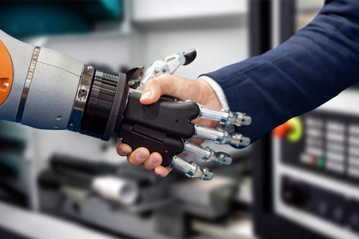 Hand of a businessman shaking hands with a Android robot.